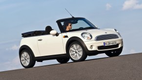 A white 2009 R57 Mini Cooper Convertible with its roof down