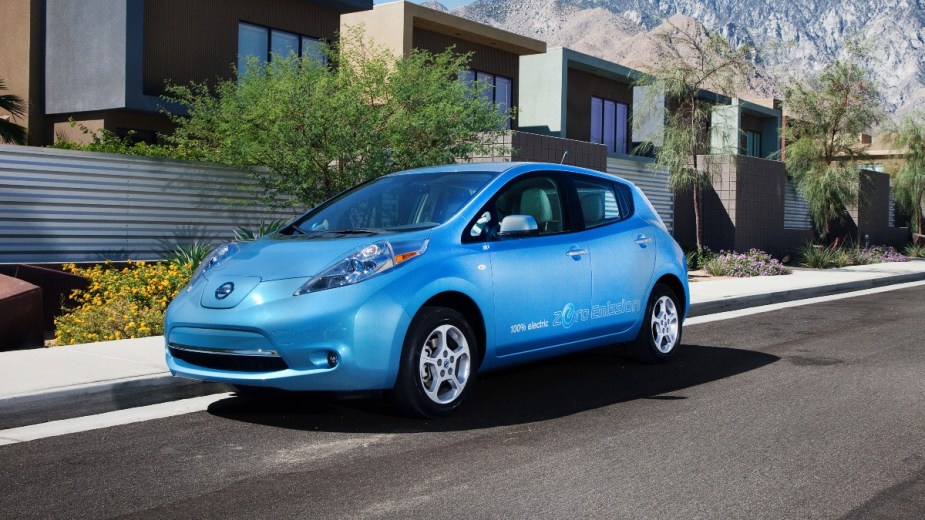 A blue 2011 Nissan Leaf parked on the side of the road