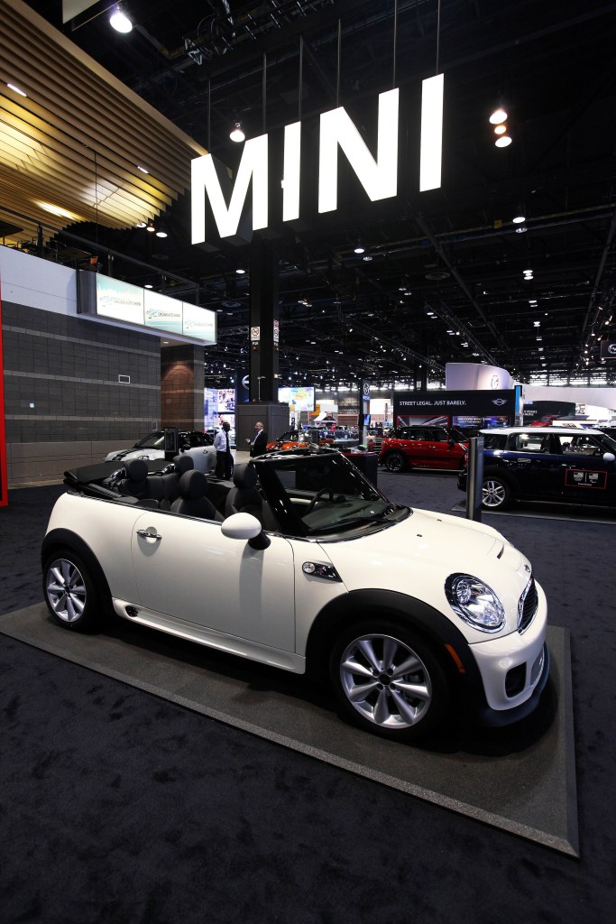 The side 3/4 view of a white 2014 R57 Mini Cooper S Convertible at the 2014 Chicago Auto Show