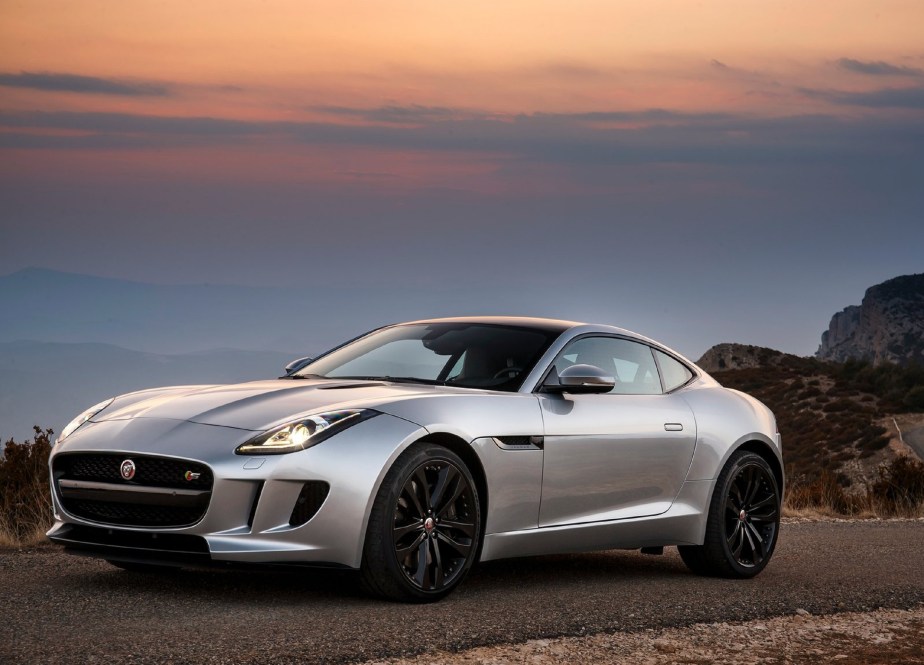 A silver 2016 Jaguar F-Type V6 S Coupe on a canyon road at sunset