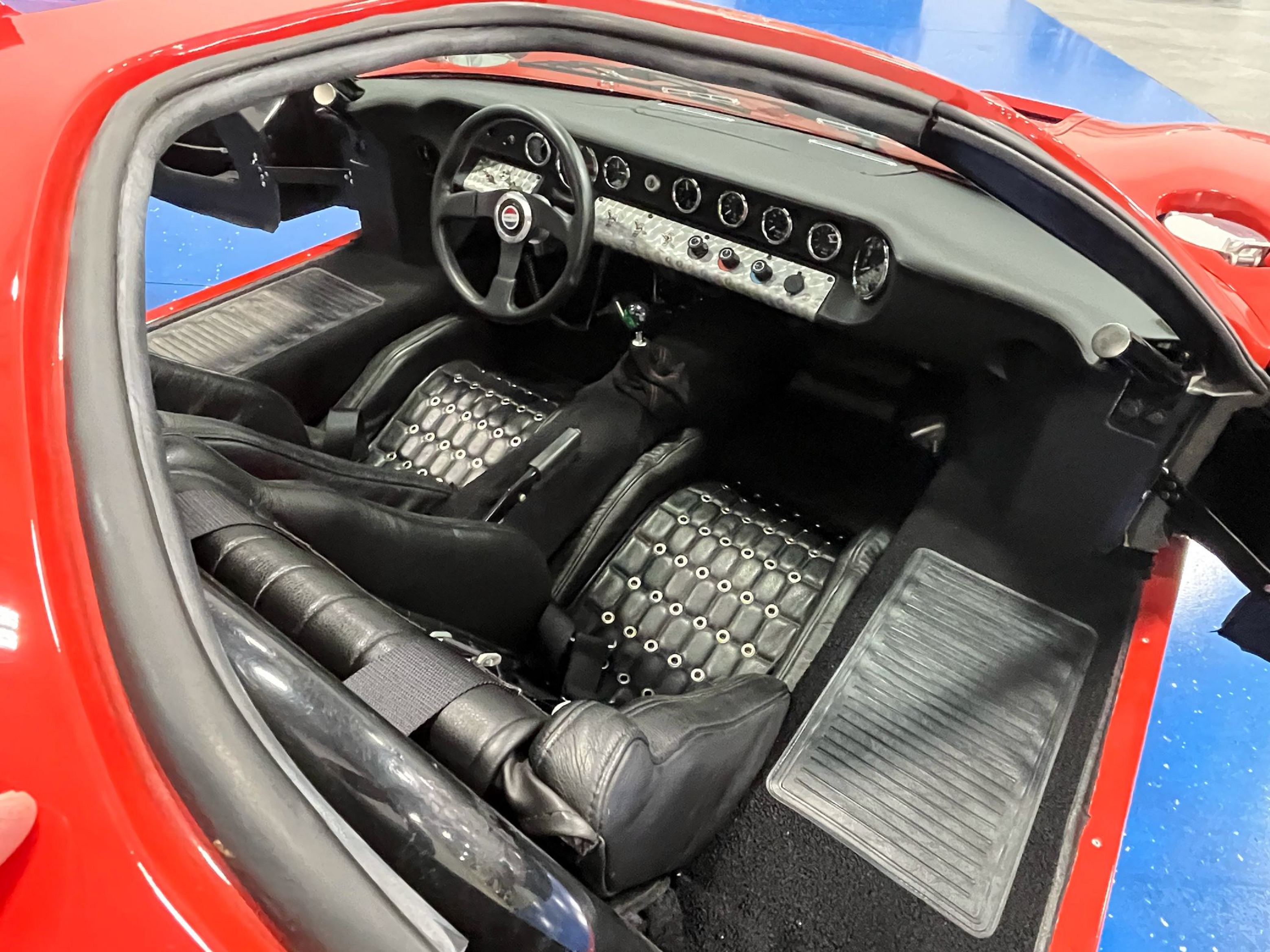 The black sports seats and dashboard of a red 2016 Race Car Replicas Ford GT40 Mk1