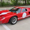A red-with-white-stripes 2016 Race Car Replicas Ford GT40 Mk1 in a parking lot