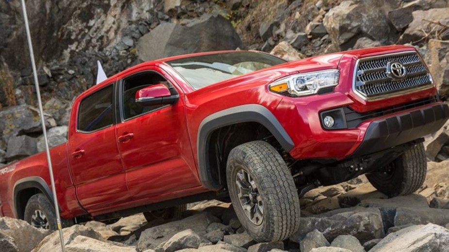 Red used 2016 Toyota Tacoma climbing on rocks