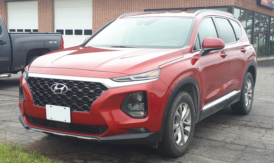 A red 2019 Hyundai Santa Fe sits parked in the street. Should you buy it used?