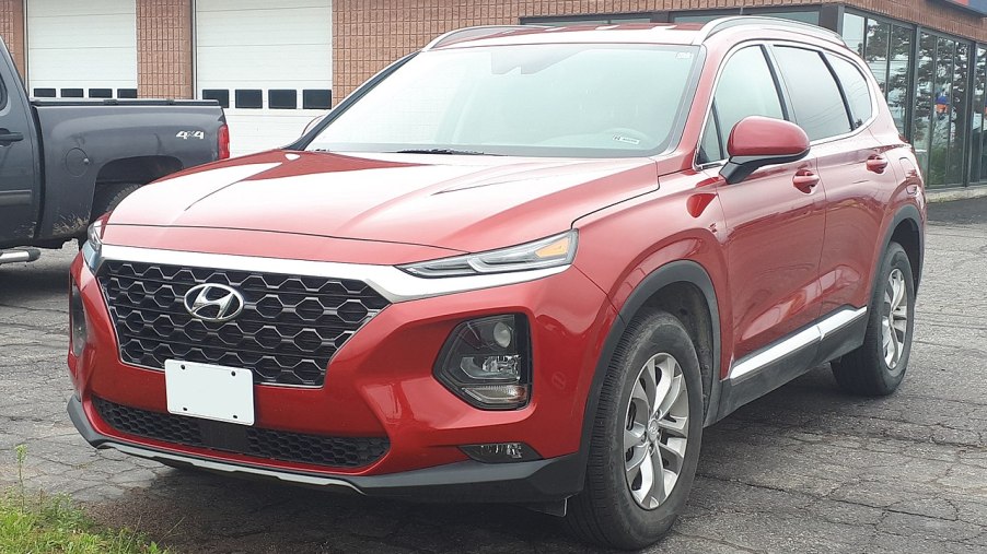 A red 2019 Hyundai Santa Fe sits parked in the street. Should you buy it used?