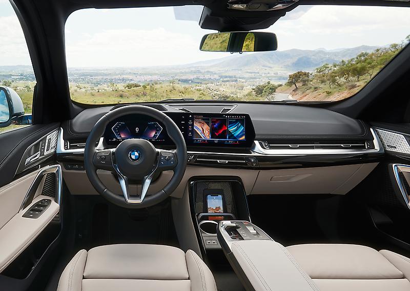 The interior of a 2023 BMW X1 in tan and black. 