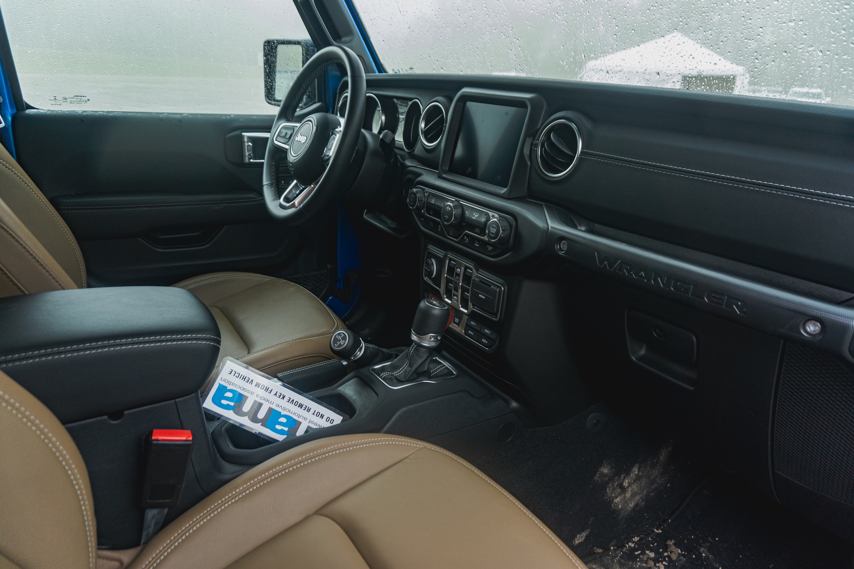 The black dashboard and brown-leather front seats of a 2021 Jeep Wrangler Unlimited Rubicon 4xe