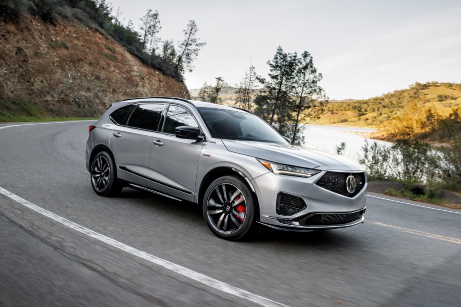 A silver 2023 Acura MDX, from the 2022 year, near a lake