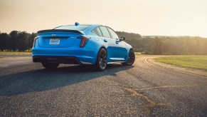 The rear 3/4 view of a blue 2022 Cadillac CT5-V Blackwing on a racetrack