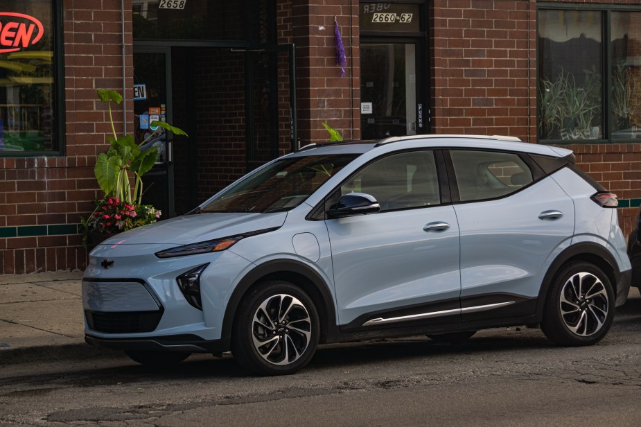 The front 3/4 view of a light-blue 2022 Chevrolet Bolt EUV Premier on a Chicago city street