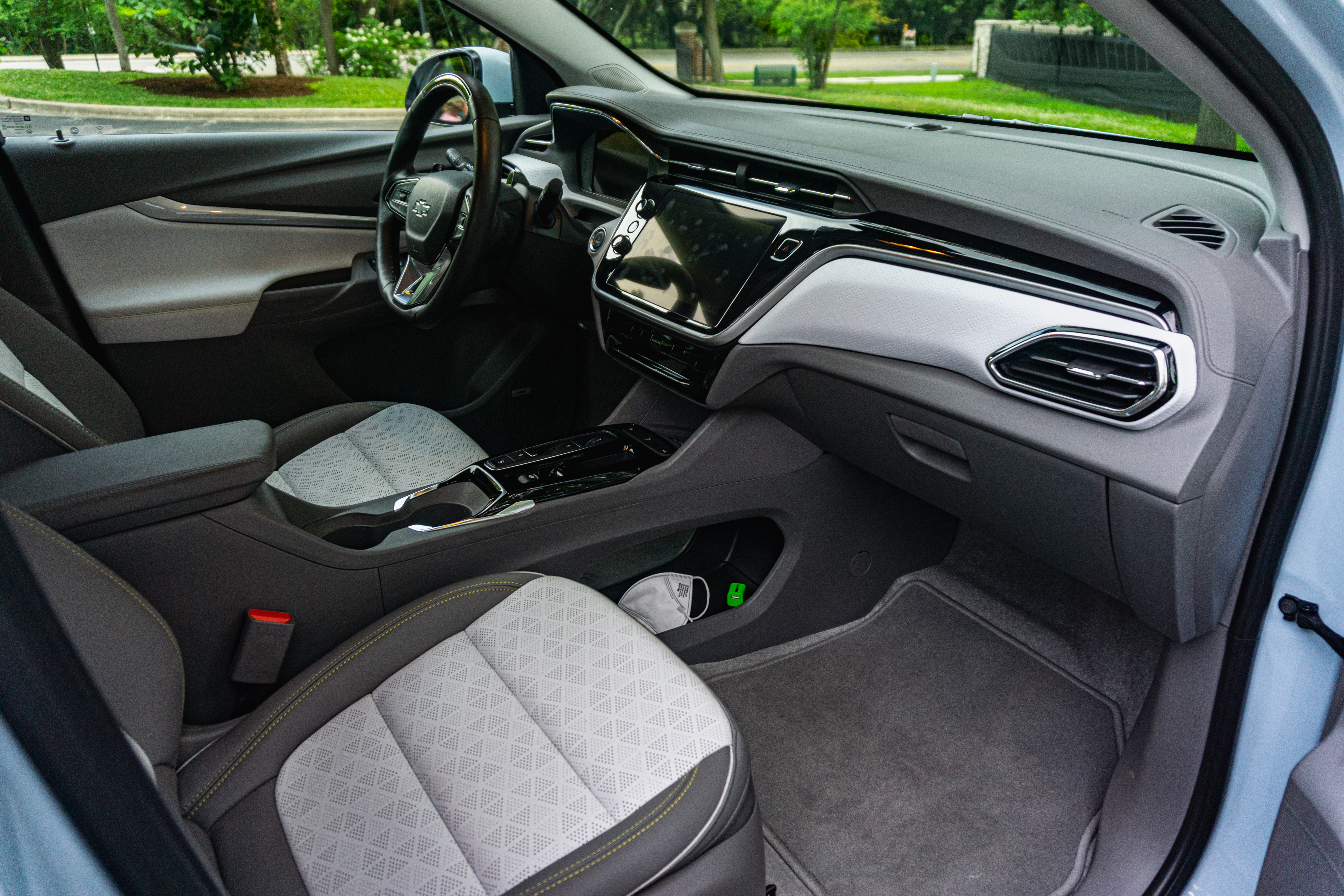 The gray-and-white-leather front seats and gray-and-white dashboard of a light-blue 2022 Chevrolet Bolt EUV Premier