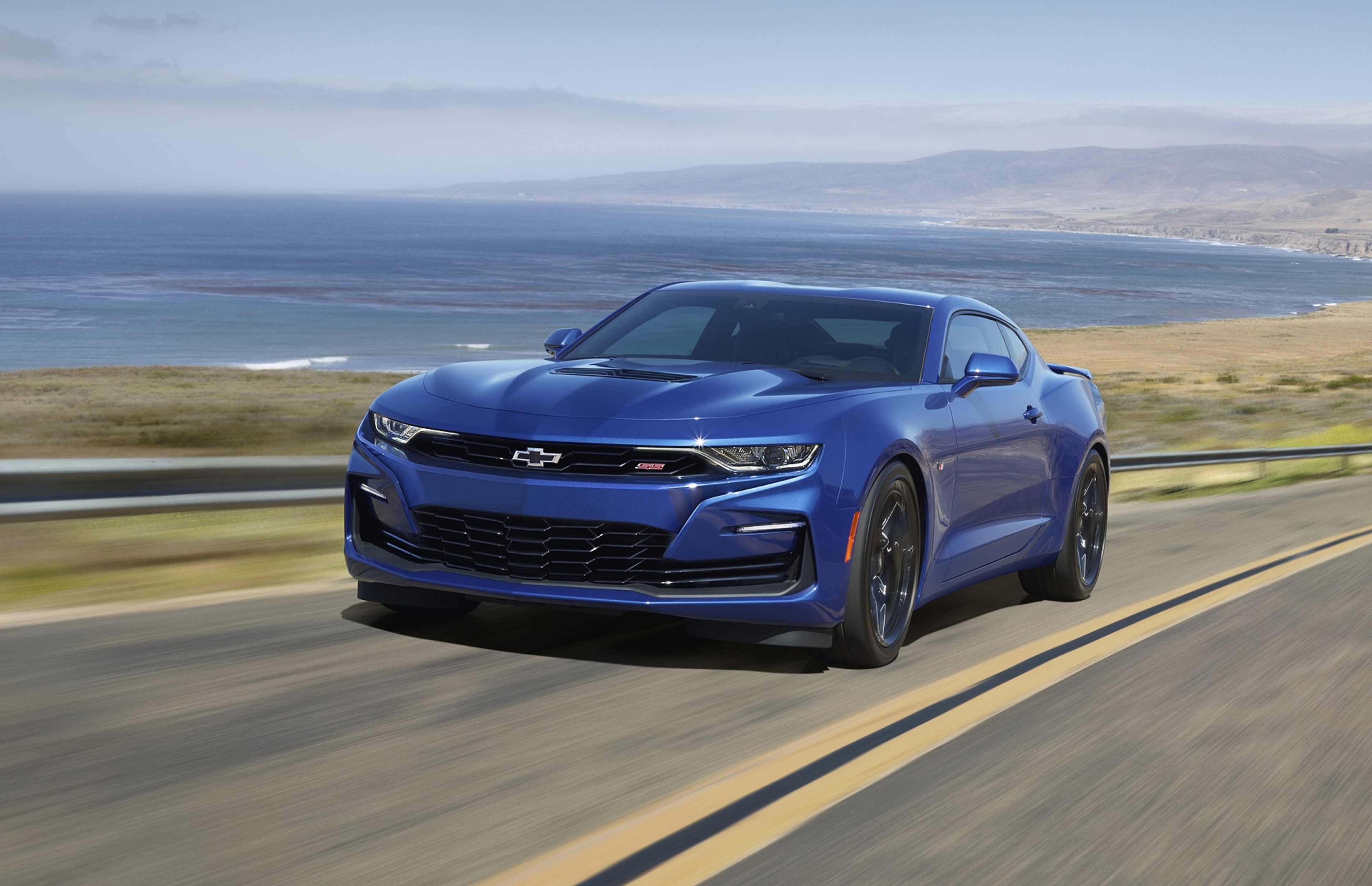 A blue 2022 Chevrolet Camaro SS driving down an oceanside cliff road