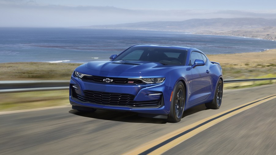 A blue 2022 Chevrolet Camaro SS driving down an oceanside cliff road