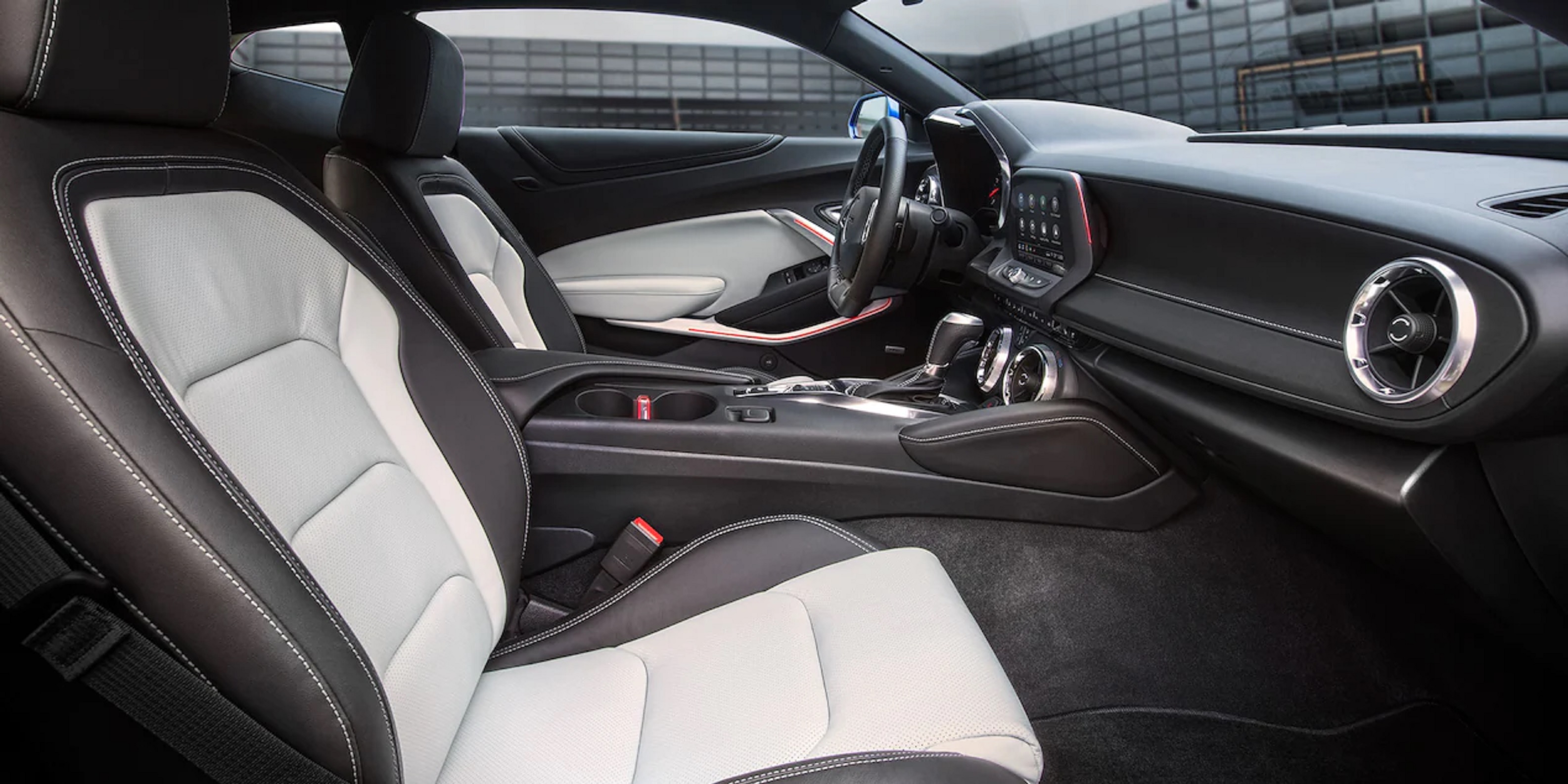The black-and-white front seats and dashboard of a 2022 Chevrolet Camaro seen from the side