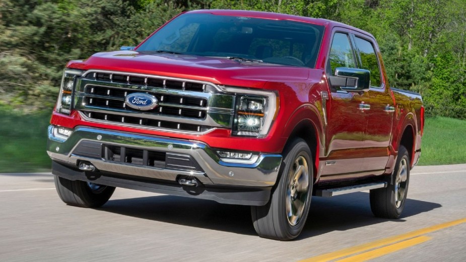 Red 2022 Ford F-150 PowerBoost Hybrid driving on a road