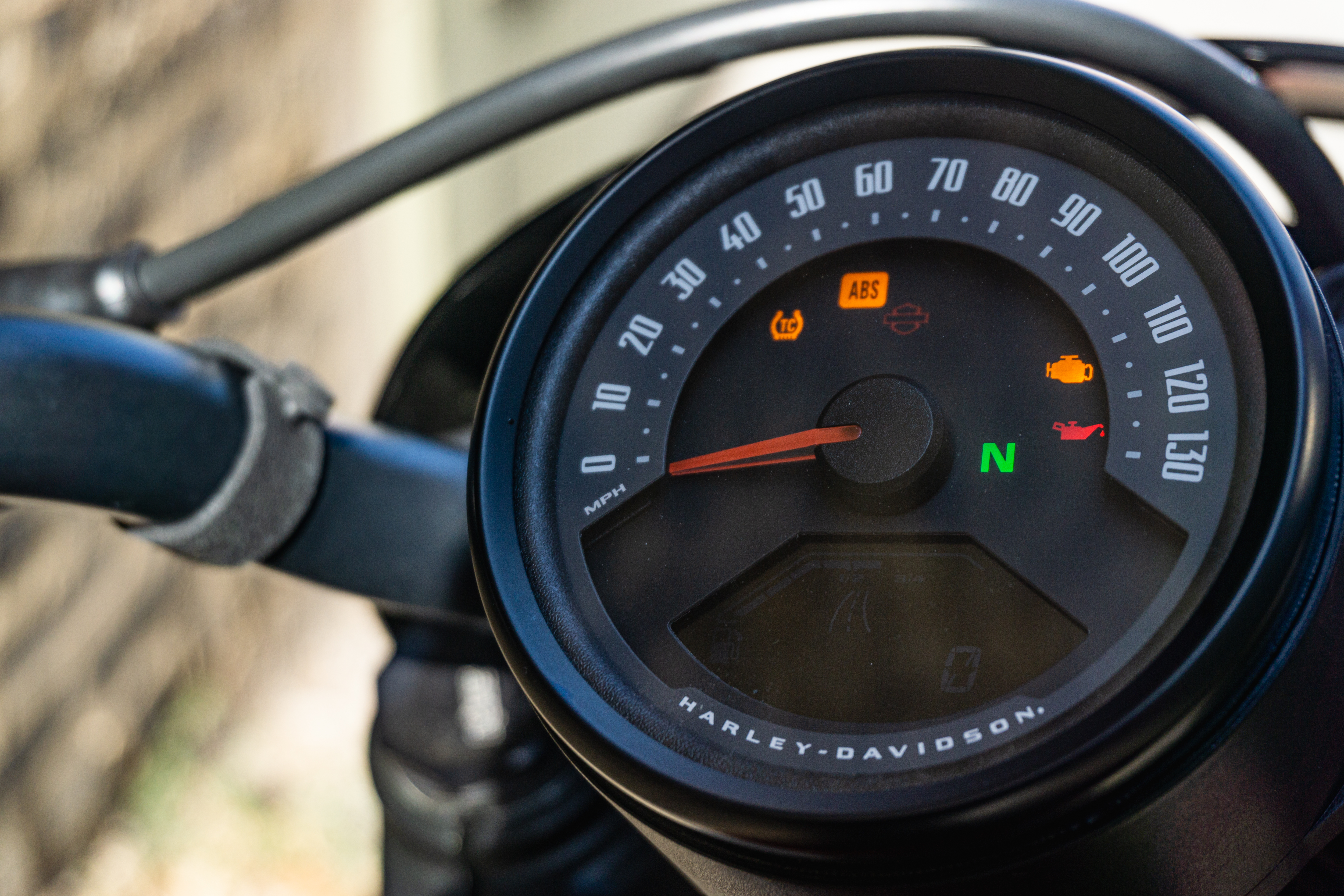 The black gauge of a 2022 Harley-Davidson Nightster in an alley