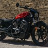 A red-and-black 2022 Harley-Davidson Nightster in front of a brick wall