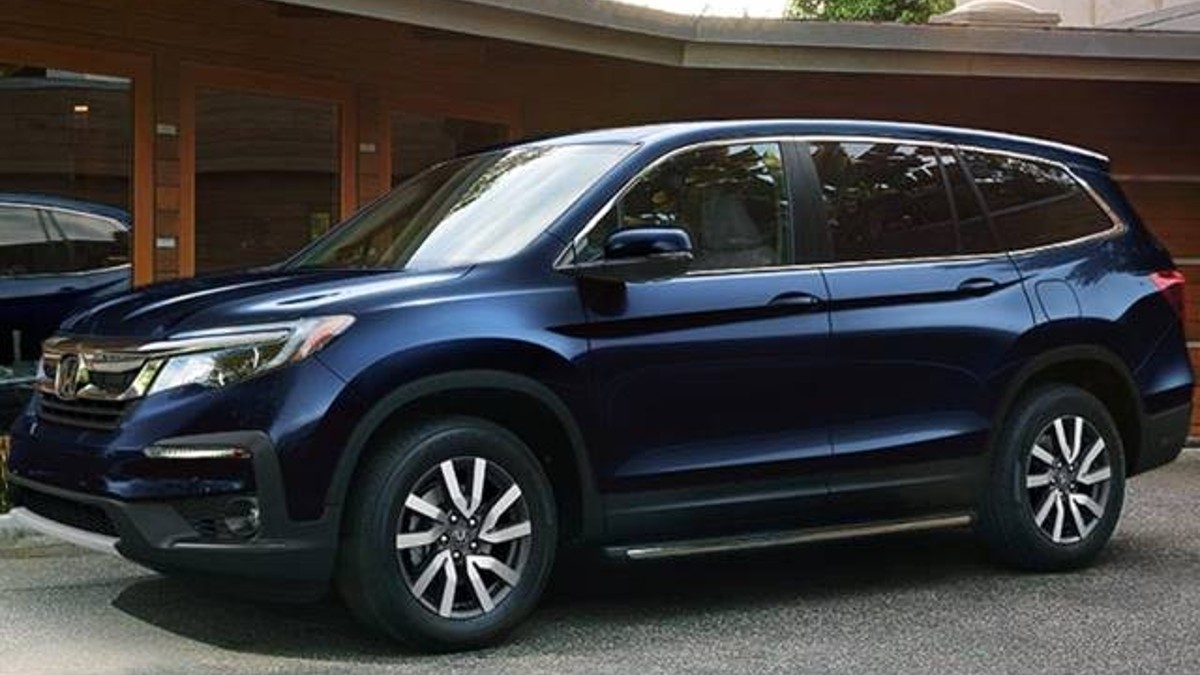 Blue 2022 Honda Pilot Touring SUV parked in front of a house