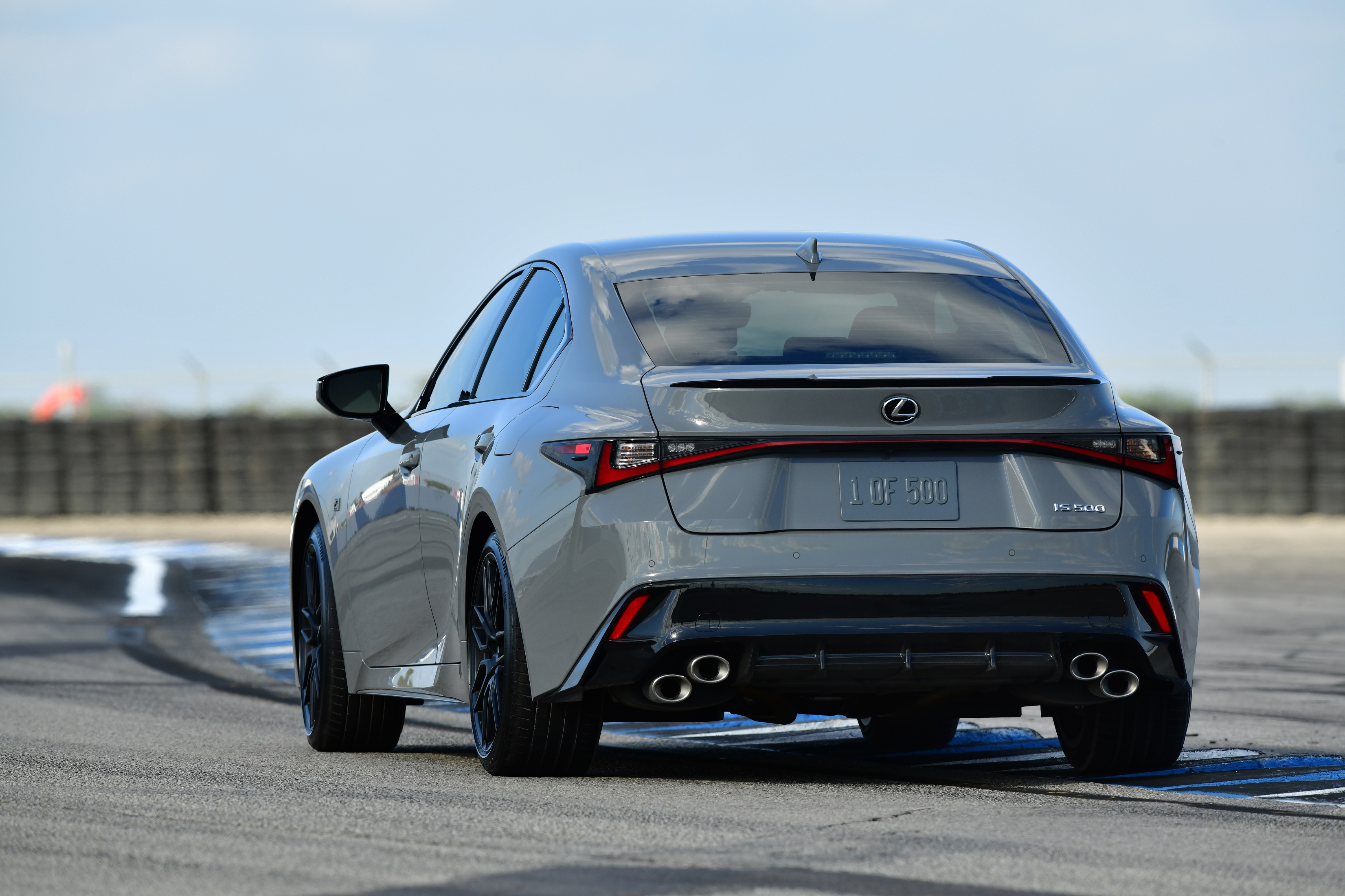 The rear 3/4 view of a gray 2022 Lexus IS 500 F Sport Performance Launch Edition on a racetrack