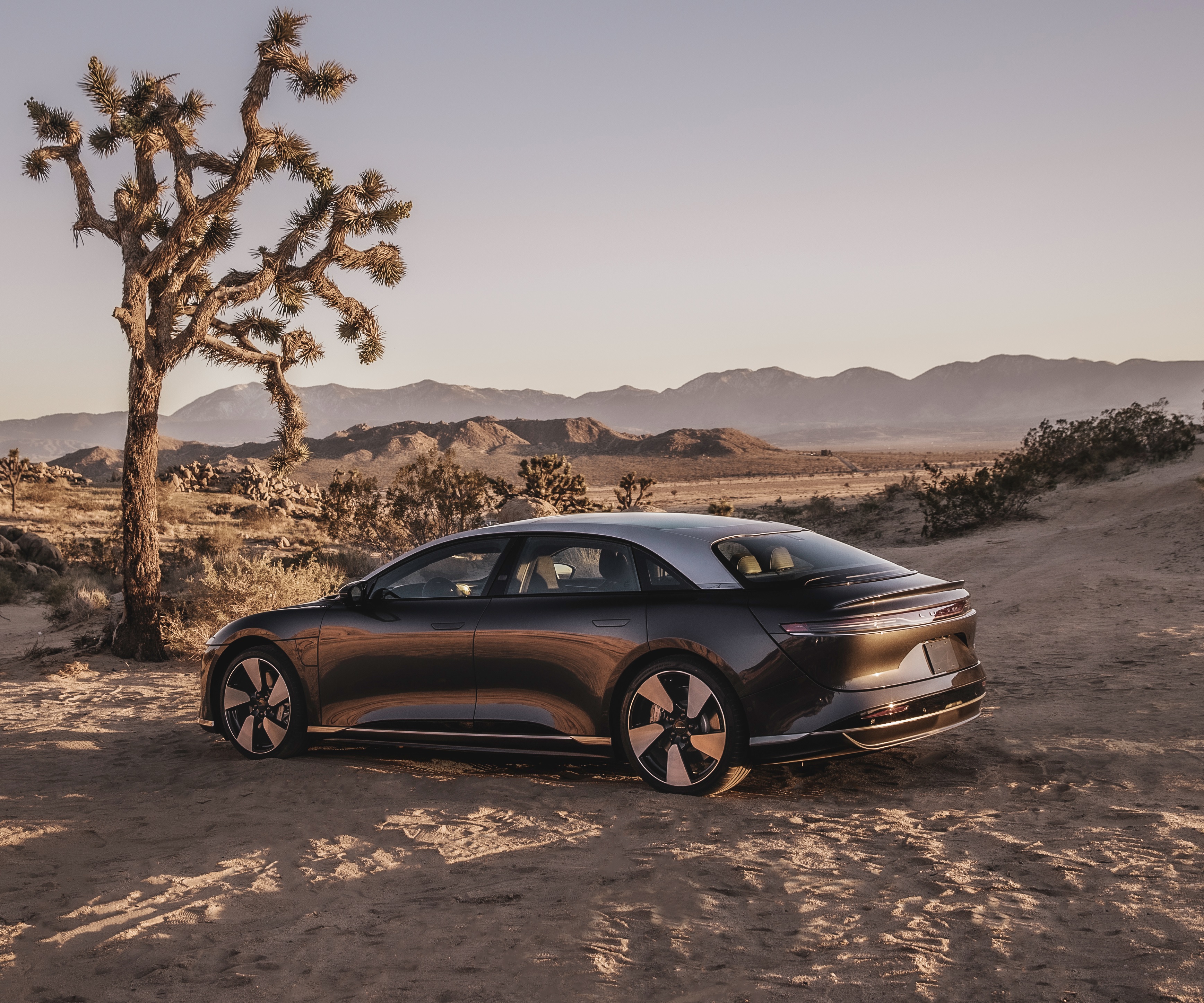 The 3/4 rear view of a gray 2022 Lucid Air Grand Touring Performance in the desert