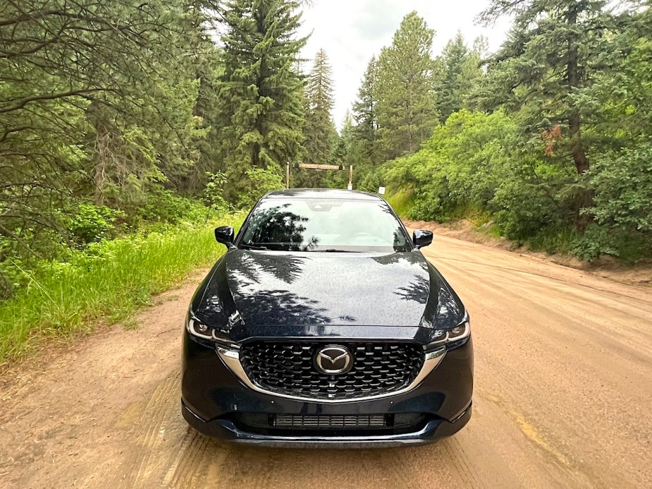 A front view of the 2022 Mazda CX-5 Turbo Signature on a dirt road.