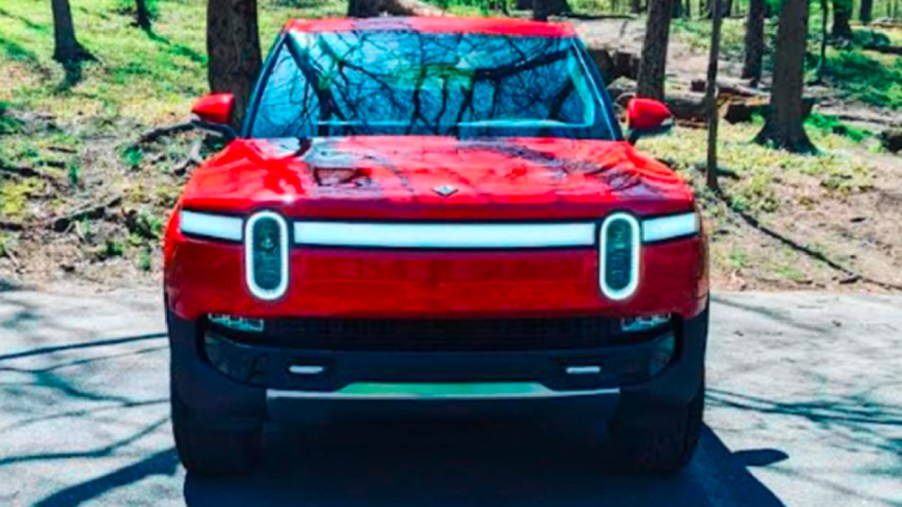 A red 2022 Rivian R1T Launch Edition electric pickup truck is parked.