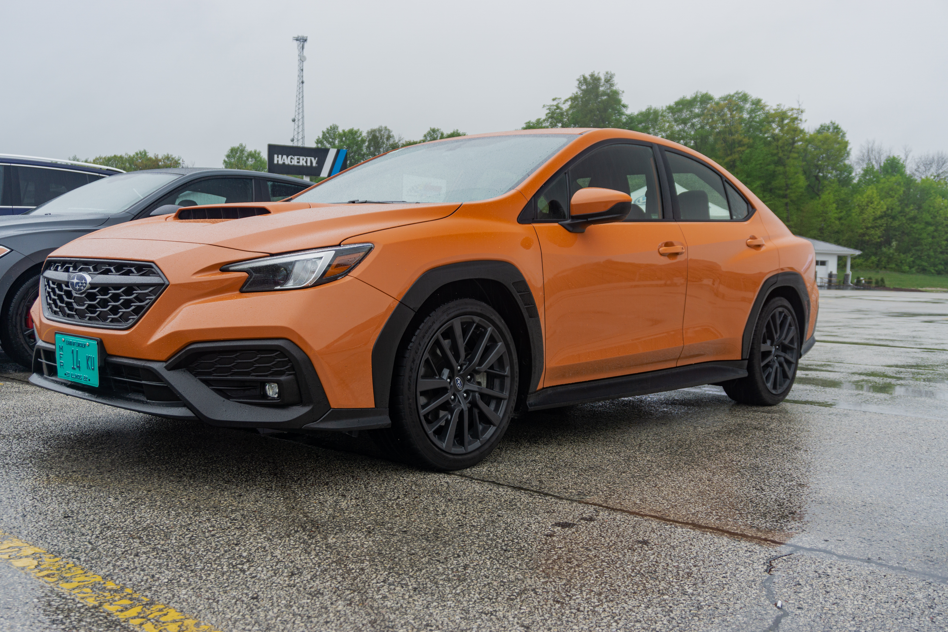 The front 3/4 view of an orange 2022 Subaru WRX Premium in the Road America parking lot