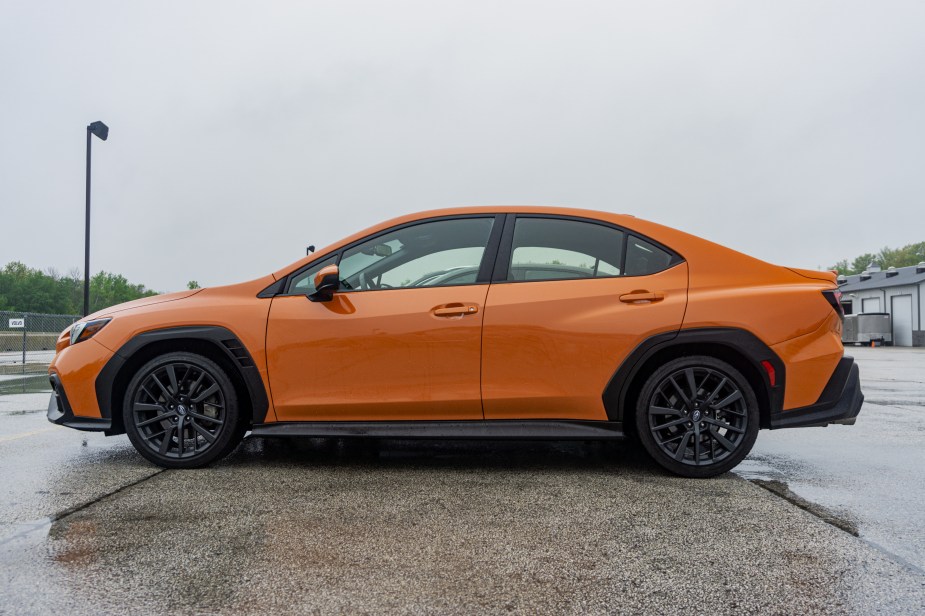 The side view of an orange 2022 Subaru WRX Premium in the Road America parking lot