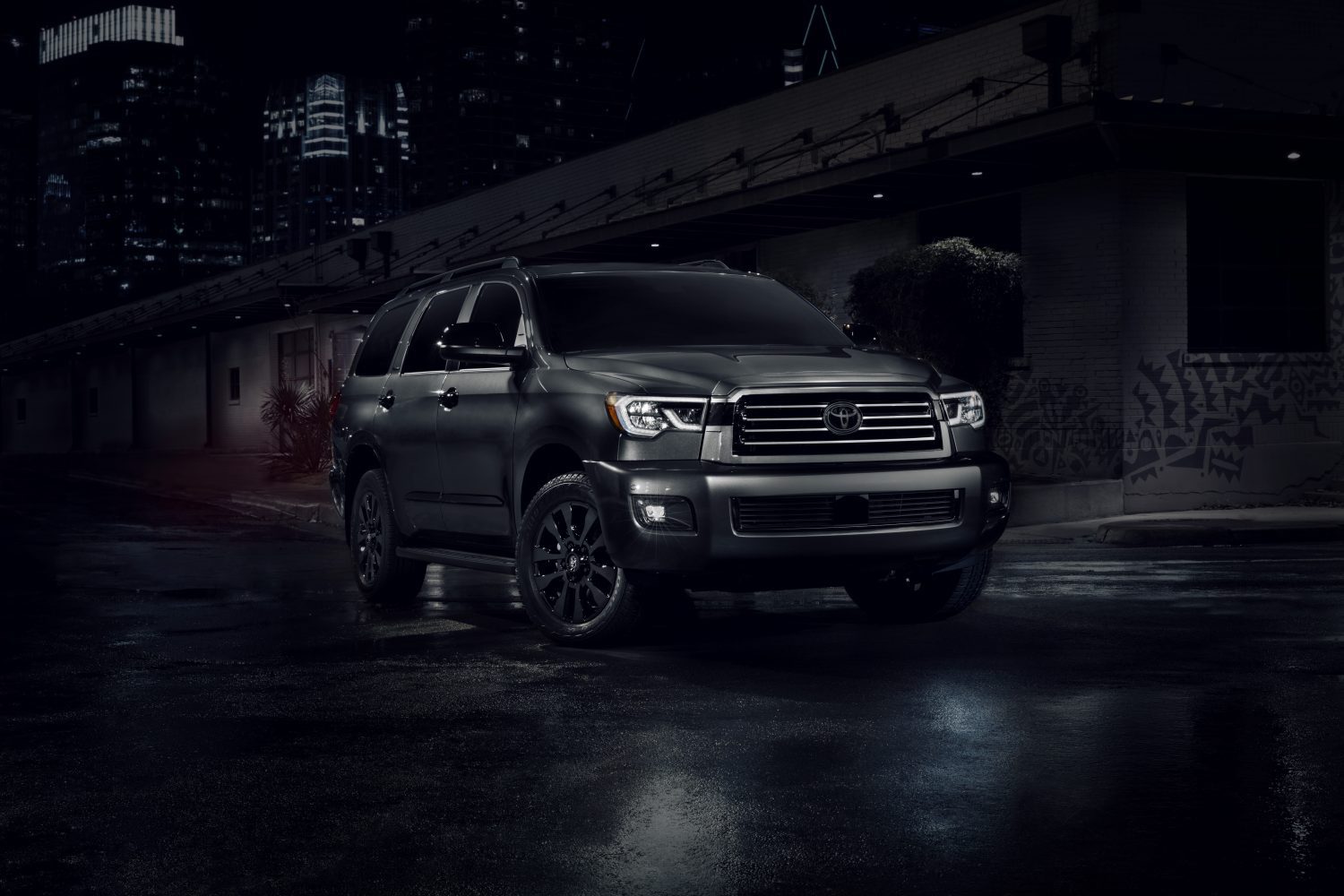 A 2022 Toyota Sequoia in dark grey parked outside in a dark outdoor area.