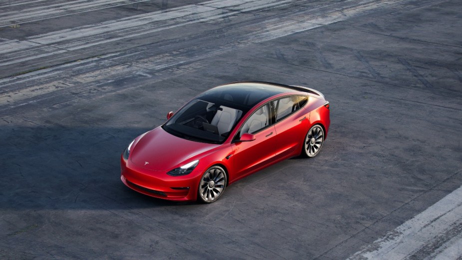 a red 2022 tesla model 3, help it stand out with unique aftermarket wheels