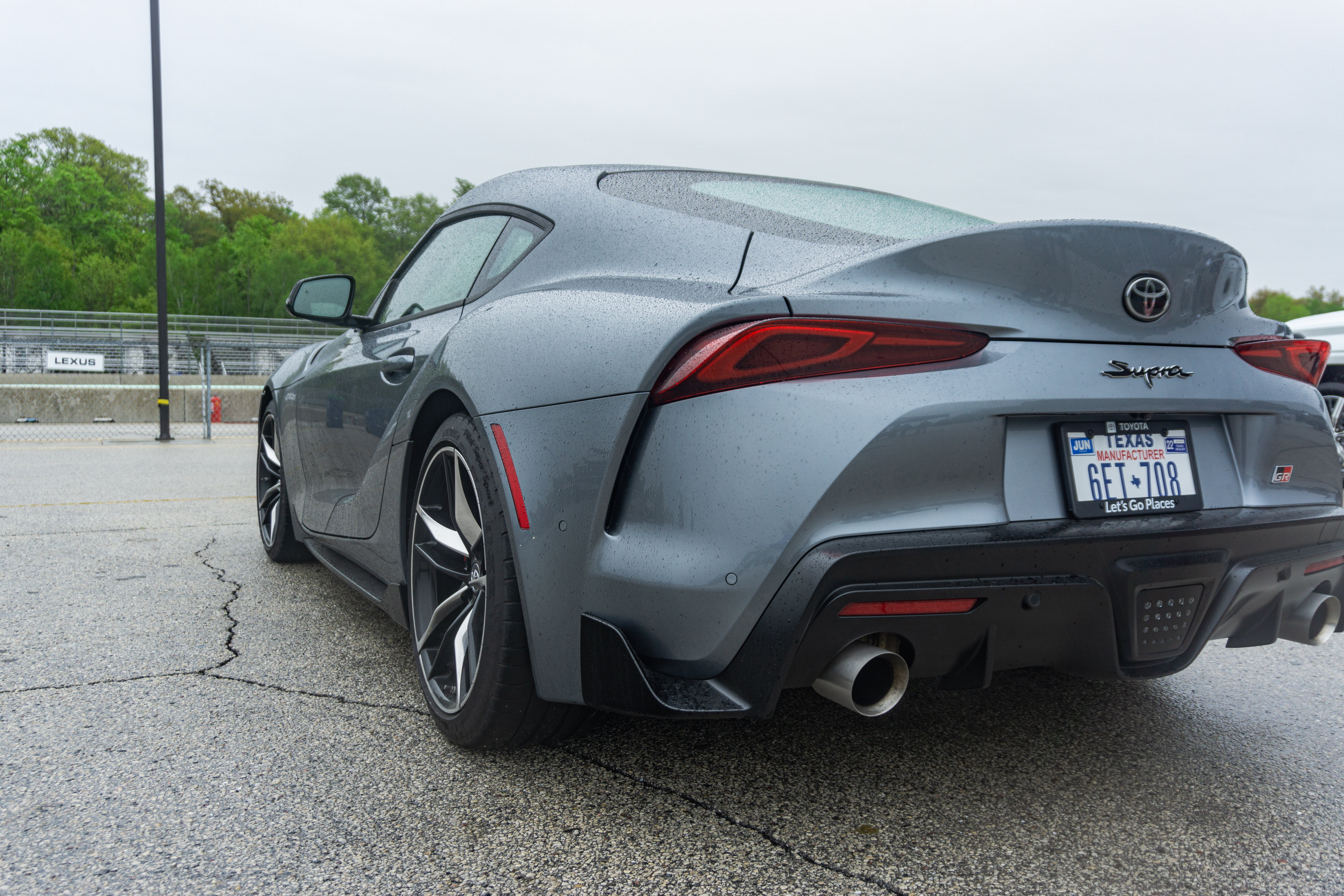 The rear 3/4 view of a gray 2022 Toyota GR Supra 3.0 Premium in Road America's parking lot