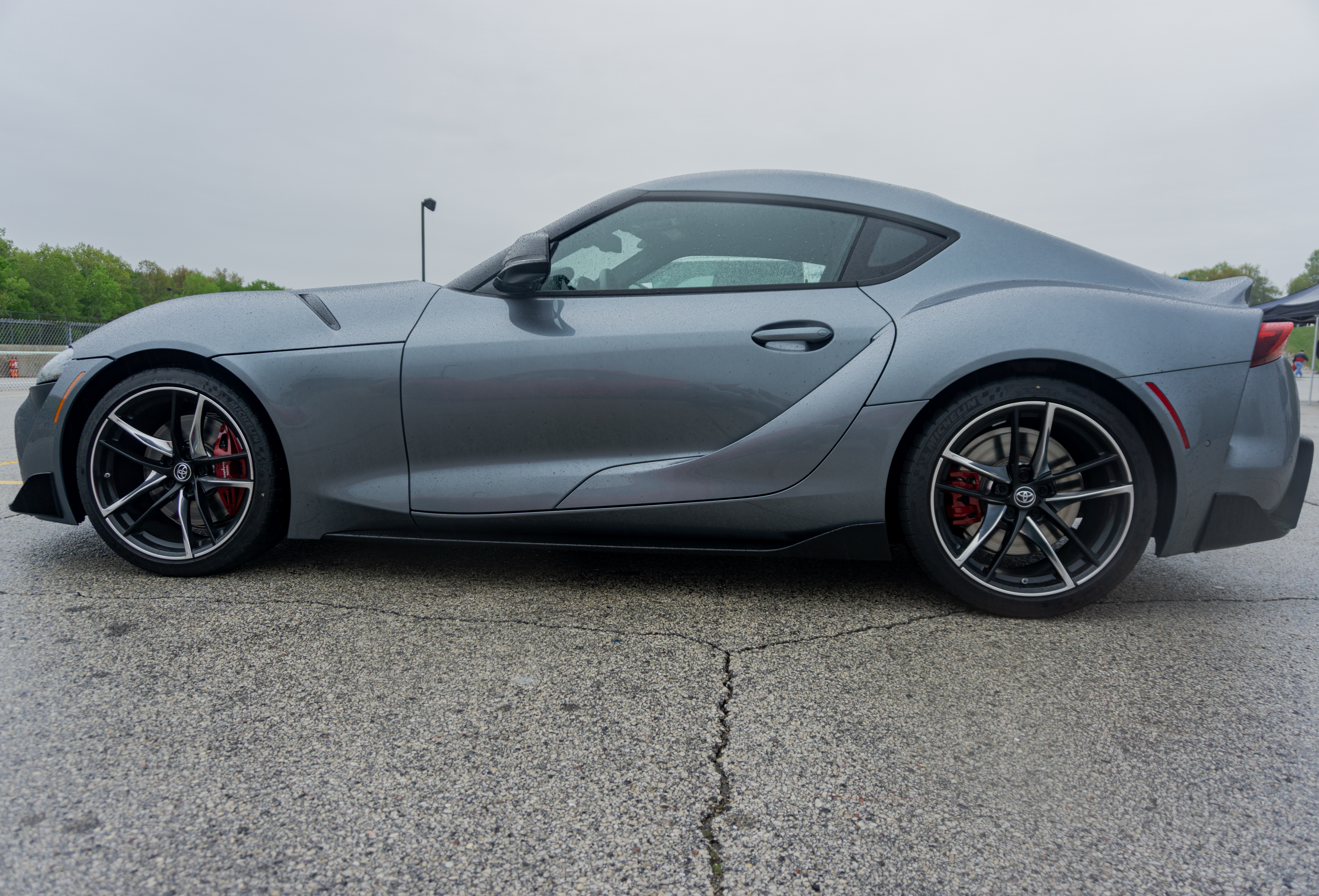 The side view of a gray 2022 Toyota GR Supra 3.0 Premium in Road America's parking lot