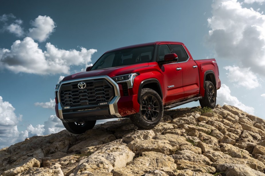 Advertising photo of a red Toyota Tundra pickup truck parked atop a pile of rocks.