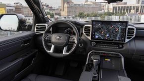 The premium interior of a Toyota Tundra pickup truck, a city visible outside its windshield.