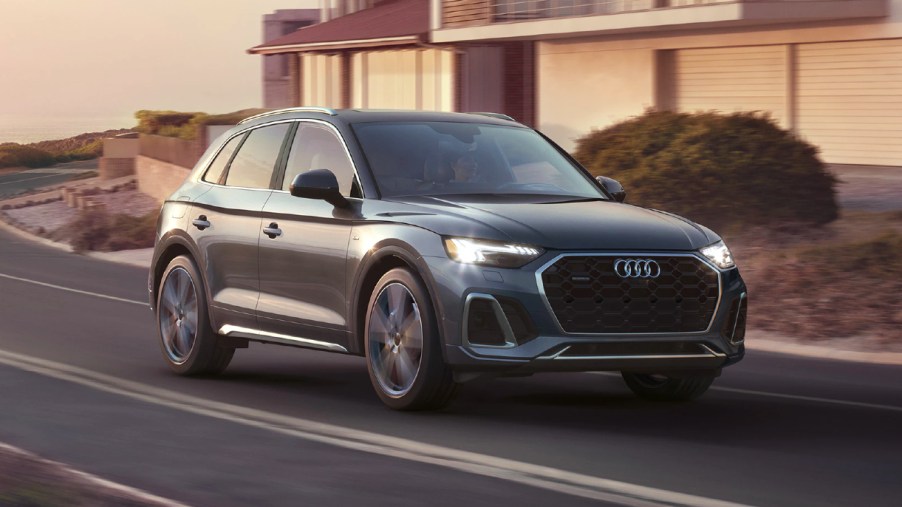 A blue 2023 Audi Q5 luxury compact SUV is driving on the road.