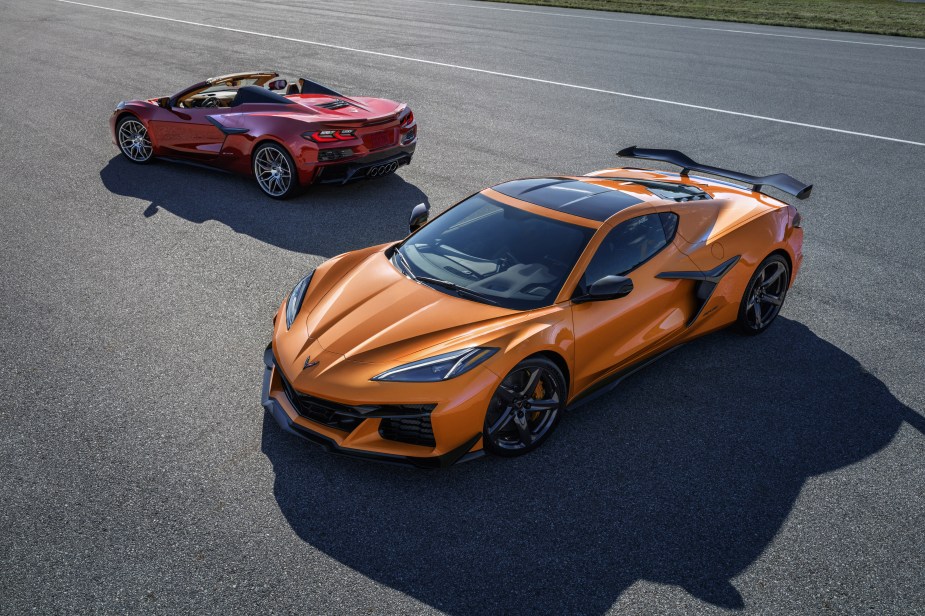 An orange 2023 C8 Chevrolet Corvette Z06 Coupé in front of a red Convertible on a track