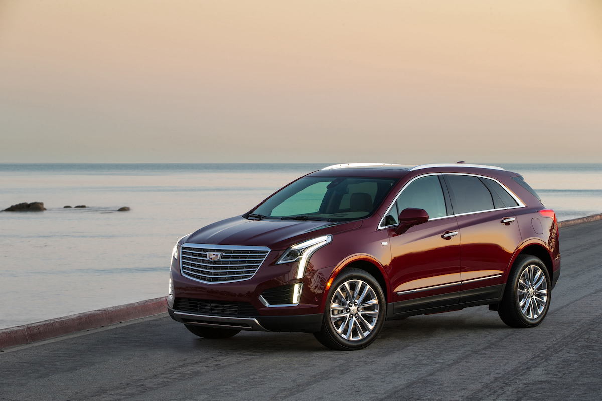 A red 2023 Cadillac XT5 parked by a beach