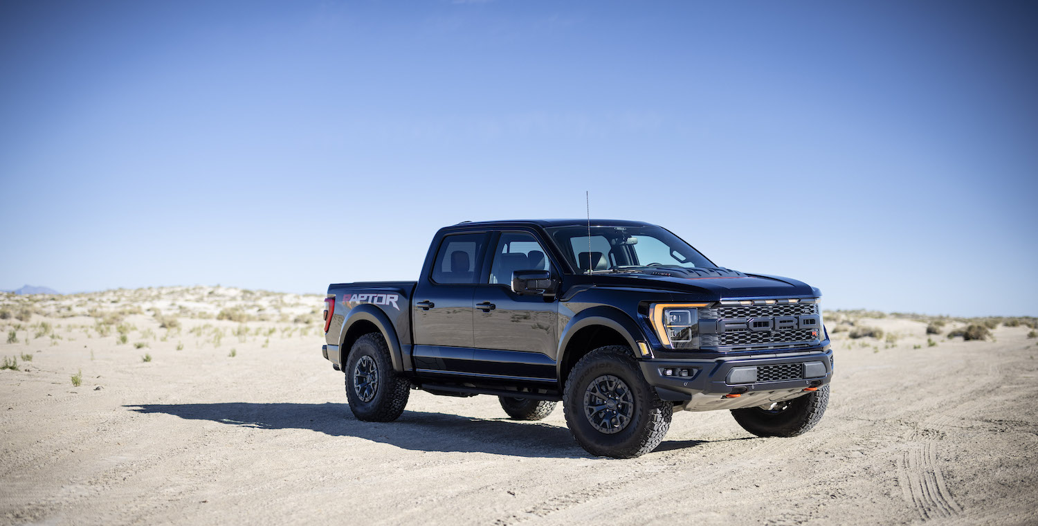Promo photo of a black Ford Raptor parked in the desert, blue sky visible in the background.