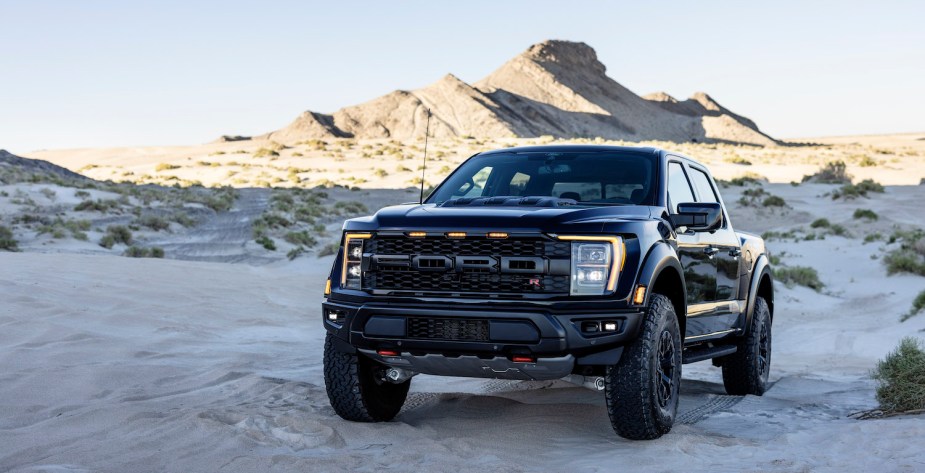 Promo of the all-new, supercharged 2023 Ford  F-150 Raptor R in black, the desert visible behind it.