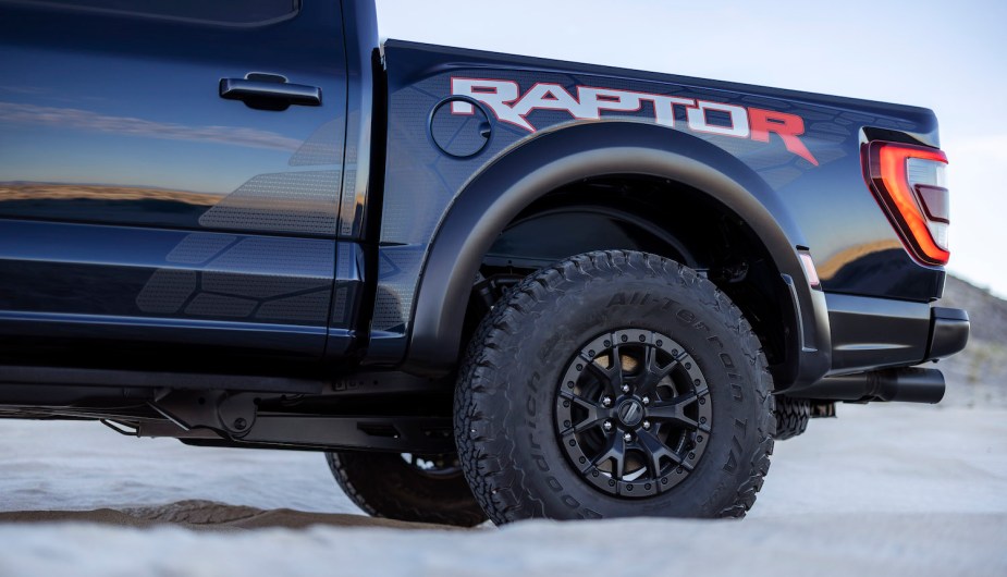 Closeup of the 37-inch tire of a black Ford Raptor R 4x4 pickup truck.