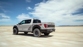 Promo photo of a gray Ford Raptor R truck driving through the desert.