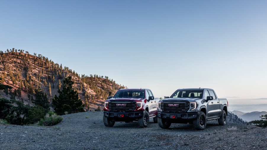 The 2023 GMC Sierra 1500 AT4X AEV Edition and the 2023 GMC Sierra 1500 AT4X parked next to each other in the daytime.