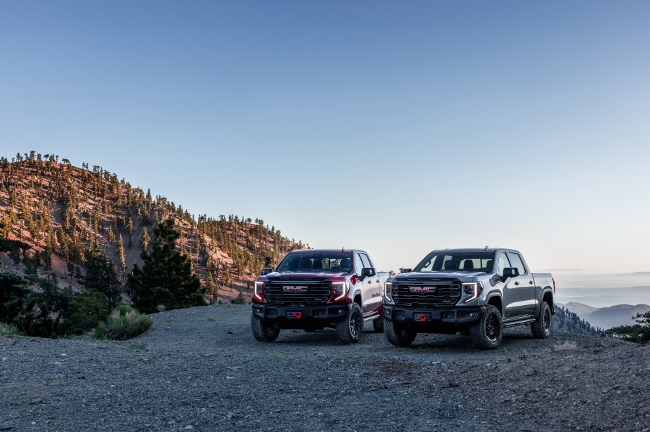 The 2023 GMC Sierra 1500 AT4X AEV Edition and the 2023 GMC Sierra 1500 AT4X parked next to each other in the daytime.