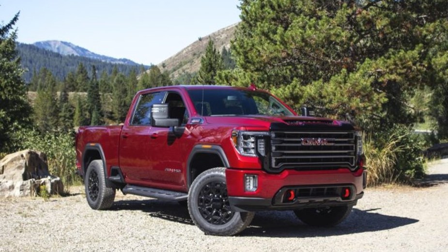 A Red 2023 GMC Sierra HD AT4 Wilderness Shot with mountains in the background of this heavy-duty truck