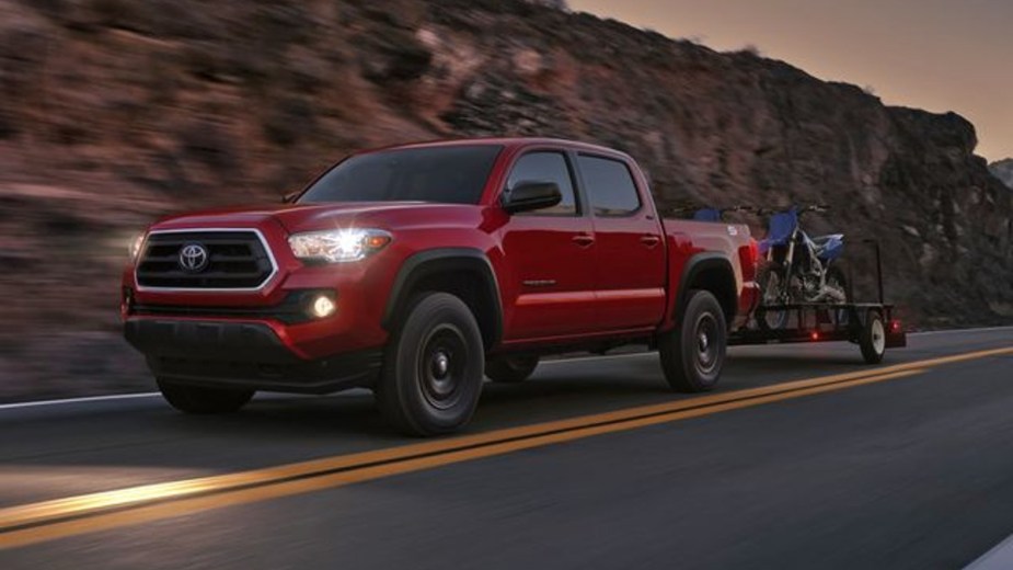 Red 2023 Toyota Tacoma Pulling a Trailer at dusk