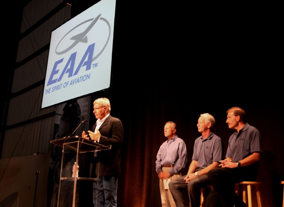 Harrison Ford speaking at an EAA event, highlighting EAA AirVenture Oshkosh at Wittman Field for the world's busiest airport