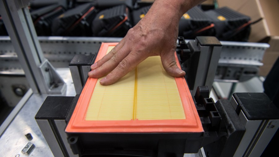 An orange-and-yellow engine air filter being assembled in Mann+Hummel's factory