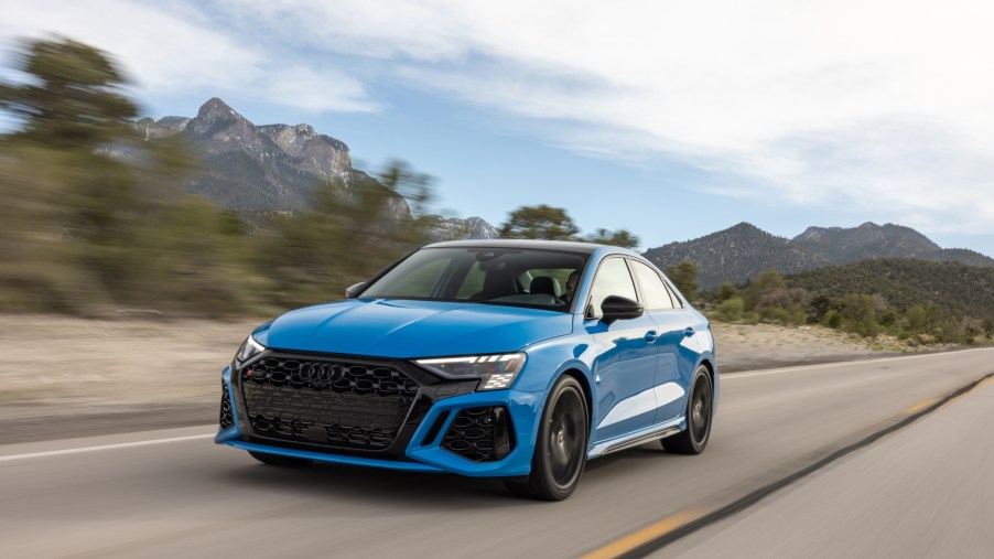A blue Audi RS3 speeding down a highway, the Audi RS3 is a performance car with torque vectoring