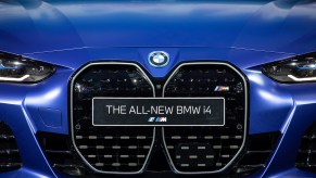 A 2022 BMW i4 in blue with a plate stating the model of the car on a close up the grille are of the car.