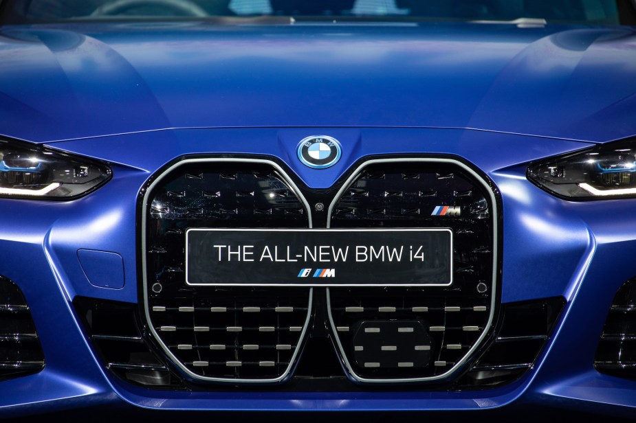 A 2022 BMW i4 in blue with a plate stating the model of the car on a close up the grille are of the car.